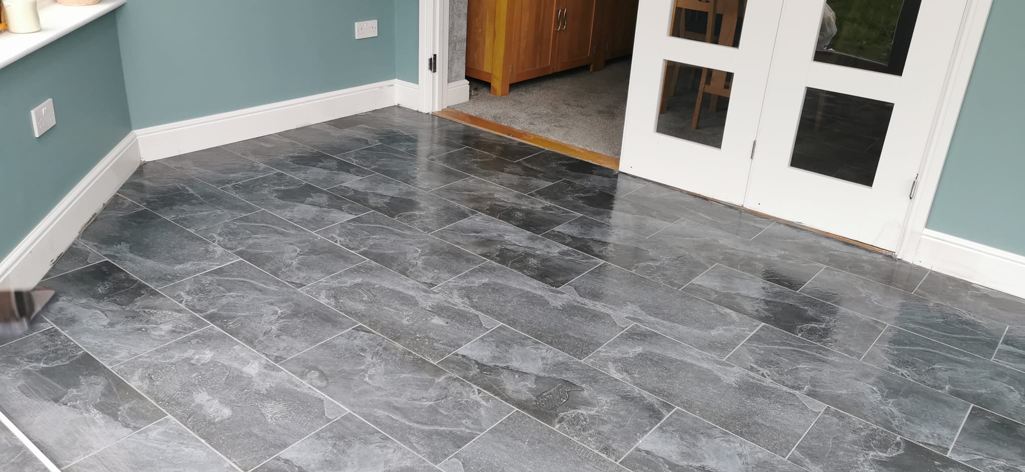 "Recently completed grouting and cleaning of a tiled floor in a home in Basildon, Essex, showcasing a pristine, smooth finish."